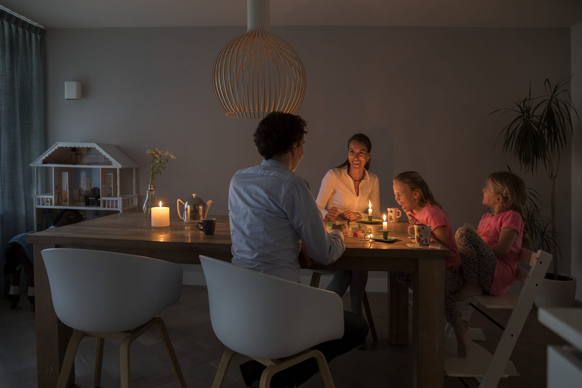 Gezin met kaarsen aan eettafel Gezin met kaarsen aan eettafel