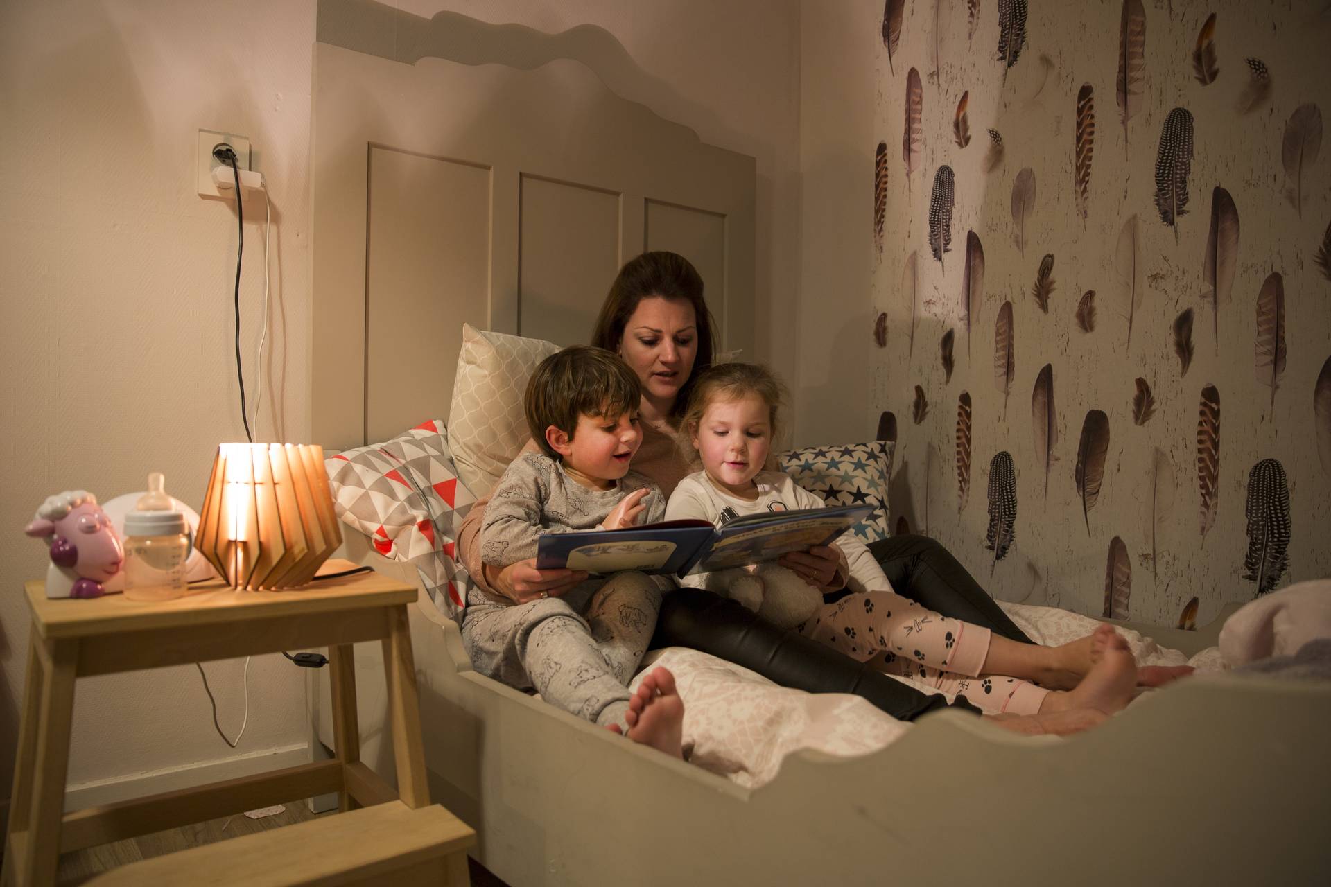 Moeder met kinderen voorlezen in bed