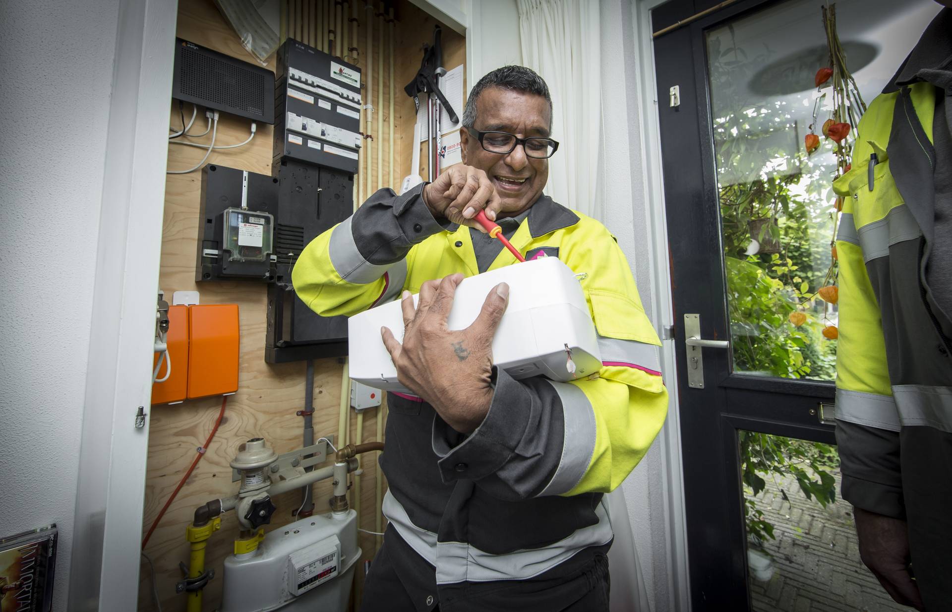 Lachende monteur bij meterkast Lachende monteur bij meterkast